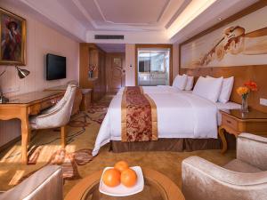 Fenghuangwei的住宿－维也纳国际酒店 (深圳福永会展中心店)，酒店客房设有一张大床和一张书桌。