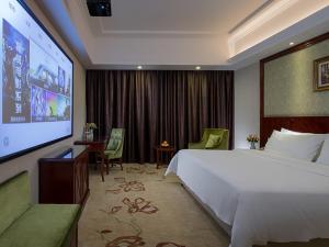 Habitación de hotel con cama grande y pantalla grande en Vienna Hotel - Jinzhou Branch, en Guangzhou