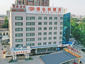 a large white building with a sign on it at Vienna Hotel Liaocheng University in Liaocheng