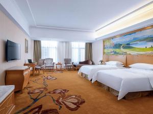 una habitación de hotel con 4 camas y una gran pintura en Vienna Hotel(Anqing Guangcai Seven-street), en Anqing