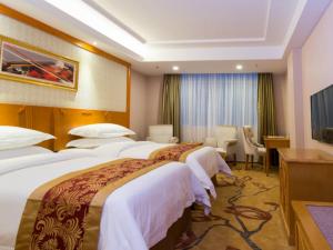 a hotel room with two beds and a desk at Vienna Hotel Guangzhou Songnan in Guangzhou