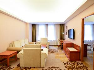 uma sala de estar com um sofá e cadeiras e uma televisão em Vienna Hotel Xinjiang Yining Shanghai City em Yining