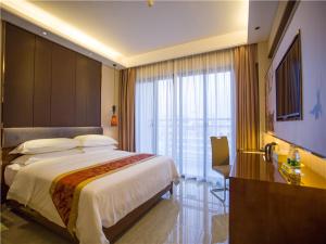 Cette chambre comprend un grand lit et une fenêtre. dans l'établissement Vienna Hotel Sanya Sanya Bay, à Sanya