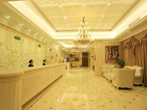 un gran vestíbulo con una peluquería con una lámpara de araña en Vienna Hotel - Jinzhou Branch, en Guangzhou