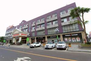 宝安にあるVienna 3 Best Hotel Shenzhen Longhuadalang Commercial Centreの前に車が駐車されている大きな建物