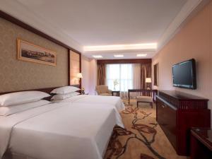 a hotel room with two beds and a flat screen tv at Vienna Hotel Foshan Nanzhuang Avenue in Foshan