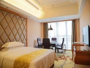 Una habitación de hotel con una cama, una mesa y sillas. en Vienna International Hotel Changsha West Bus Station, en Changsha 5 fotos más