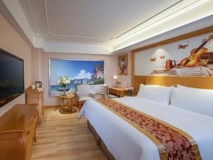 a hotel room with a large bed and a flat screen tv at Venus International Hotel Shenzhen Gongming Tianhong in Xitian