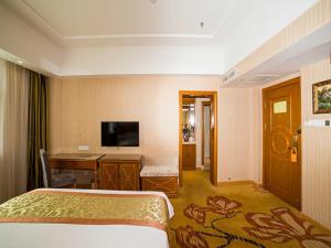 a hotel room with a bed and a desk at Vienna Hotel Shandong Yantao Golden Beach Taishan Road in Yantai +11 photos