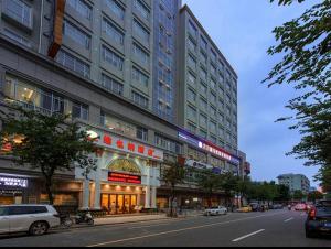 a city street with cars parked in front of a building at Vienna Hotel Zhongshan XiaoLan in Zhongshan