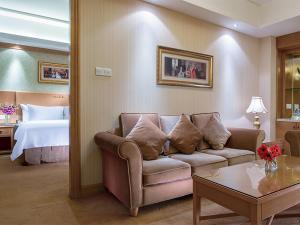 寶安的住宿－維也納國際酒店深圳龍華萬眾城店，客厅配有沙发和1张床