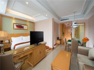 a hotel room with a bed and a living room at Vienna Hotel Tianbao Road in Shenzhen +2 photos