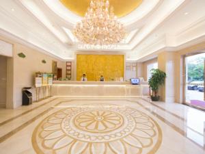 a large lobby with a chandelier and a large rug at Vienna Hotel Guangzhou Nanpu Station in Guangzhou