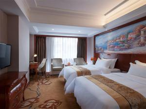 a hotel room with two beds and a television at Vienna International Hotel Shaoguan Fengcailou in Shaoguan