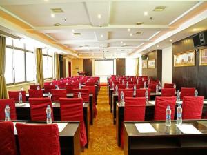 a conference room with red chairs and tables and a screen at Vienna Hotel Suzhou Zhenzhuhu Road in Suzhou