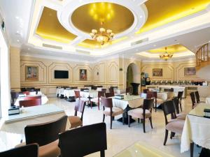 a dining room with tables and chairs in a restaurant at Vienna Hotel Qidong South Gongyuan Road in Qidong