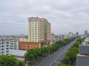 a city street with a tall building and a road at Vienna Hotel HaiNan Oriental Avenue in Dongfang