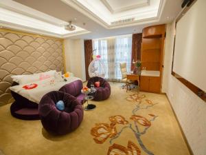 a hotel room with a bed and two ottomans sidx sidx at Vienna International Hotel Xi'an Hancheng Lake in Xi'an