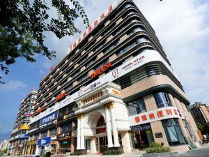 a large building with signs on the front of it at Vienna International Hotel Hangzhou Zhuantang Art School in Wenyan