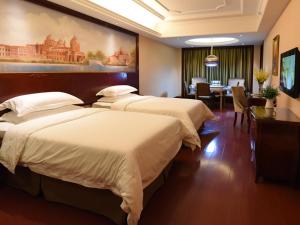 a hotel room with two beds and a dining room at Vienna Hotel Loudi Chunyuan Pedestrian Street in Loudi