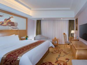 a hotel room with a large bed and a television at Vienna International Hotel Guangdong Foshan Shunde Ronggui in Shunde