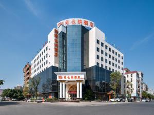 a large building with a sign on top of it at Vienna Hotel Dongguan Qiaotou in Qiaotou