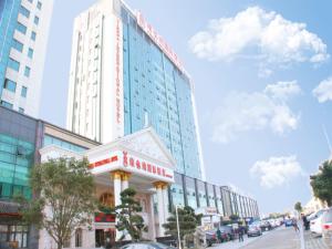 Vienna International Hotel Ningbo South Huancheng Road في نينغبو: مبنى طويل امام شارع فيه سيارات