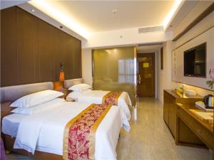 a hotel room with two beds and a television at Vienna Hotel Sanya Sanya Bay in Sanya