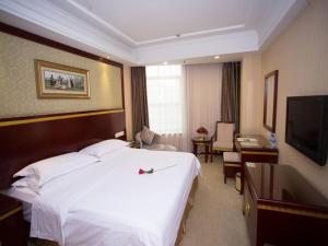 una camera d'albergo con un grande letto e una TV di Vienna Hotel Nanchang Hongcheng a Nanchang