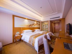 輝南にあるVienna international hotel shanghai pudong airport south storeのベッド2台とテレビが備わるホテルルームです。