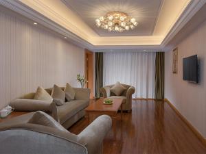 ein Wohnzimmer mit Sofas und einem Kronleuchter in der Unterkunft Vienna Hotel (Quanzhou Bus Station) in Quanzhou
