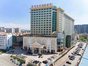 un gran edificio con coches estacionados en un estacionamiento en Vienna International Hotel - Long Hua Wan Zhong Cheng Branch en Bao'an