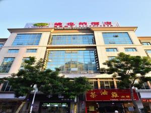 a large building with a sign on top of it at Vienna Hotel Dongguan Hou street Wanda Plaza in Dongguan