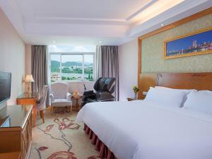 a hotel room with a large bed and a window at Vienna 3 Best Hotel Shenzhen Henggang Cuihu Shangzhuang in Longgang