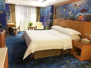 a bedroom with a large bed in a room with an aquarium at Vienna Hotel Zhongshan Central Coach Station in Changzhou +5 photos