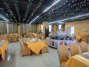 a banquet hall with tables and chairs and a buffet at Vienna Hotel Huizhou Chenjiang Avenue in Huizhou