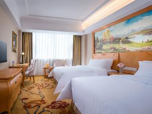 una camera d'albergo con due letti e una scrivania di Vienna Hotel Shenzhen Lo Wu Control Point a Shenzhen