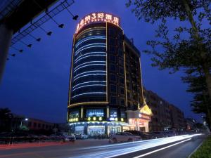 een hoog gebouw met 's nachts een bord erop bij Vienna 3 Best Hotel Dongguan Shida Road in Liaobu