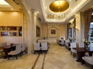 a restaurant with tables and white chairs and a chandelier at Vienna Hotel Fujian Xiapu in Xiapu