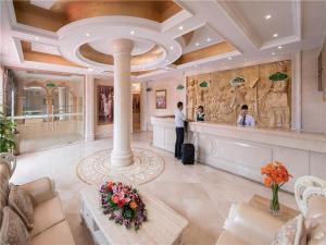 a man standing at a counter in a hotel lobby at Vienna Hotel Tianbao Road in Bao'an