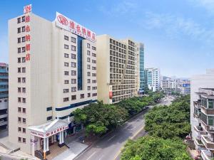 東莞市にあるVienna Hotel Guangdong Gaozhou City East Passenger Depotの高層ビルと通りがある都市
