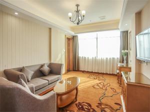a living room with a couch and a table at Vienna Hotel Fuzhou Linchuan Avenue in Fuzhou