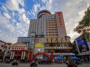 duży budynek w mieście z ludźmi na motocyklach w obiekcie Vienna Hotel Yulin Jincheng Zhenlin w mieście Yulin