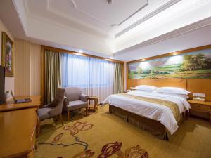 a hotel room with a large bed and a desk at Vienna international hotel shanghai pudong airport south store in Nanhui +10 photos
