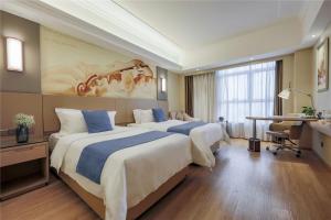 a hotel room with two beds and a desk at Vienna International Hotel Chong Qing Yu Bei Airport in Chongqing