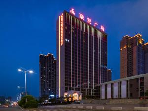 wysoki budynek z znakiem na górze w obiekcie Vienna International Hotel Hengyang Chuanshan Road Branch w Hengyang