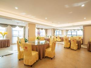 uma sala de jantar com uma mesa e cadeiras amarelas em Vienna Hotel Zhejiang Huzhou Changxing Mingzhu Road em Changxing
