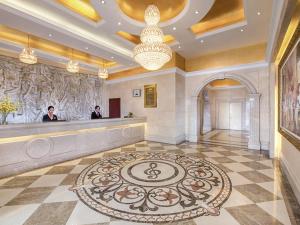 a lobby with two men standing at a cash register at Vienna Hotel Longgang Longdong in Longgang