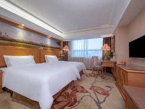 a hotel room with a large bed and a television at Vienna International Hotel Beijing GuangAnMen in Beijing