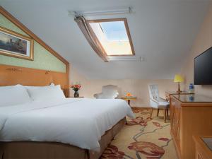 a hotel room with a large bed and a window at Vienna International Hotel Lijiang Yuxue Avenue in Lijiang